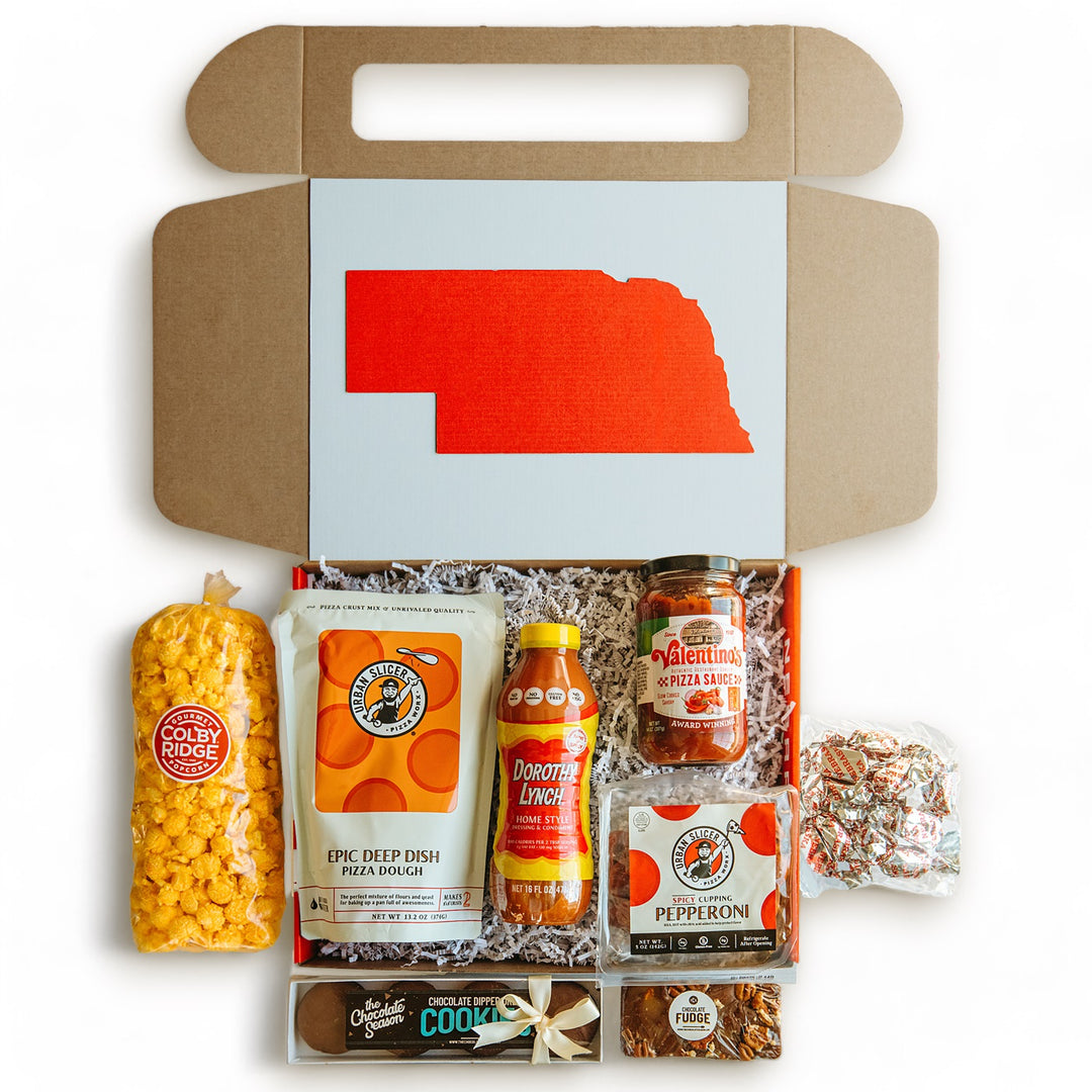 Nebraska pizza night gift box open with various food items inside including pizza dough, pizza sauce, popcorn, pepperoni, salad dressing, mint meltaways, chocolate covered Oreos, and walnut fudge.